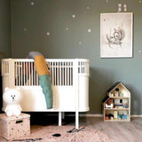 A colorful nursery with a crib adorned with cartoon baby bedding from Baby Bliss Haven, highlighting the playful, decorative aspect of infant accessories.